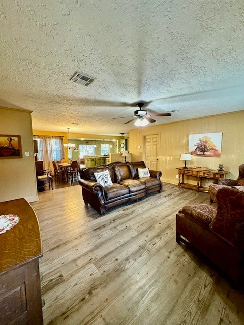 living room with ceiling fan, a textured ceiling, and hardwood / wood-style flooring