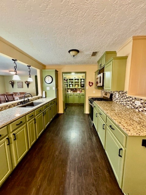 kitchen featuring dark hardwood / wood-style floors, stainless steel appliances, sink, decorative light fixtures, and a textured ceiling