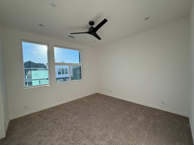 carpeted spare room with ceiling fan