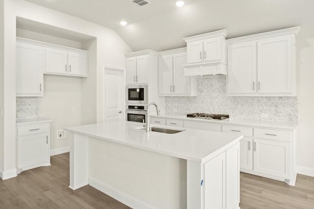 3909 Birch Grove Bnd, Denton, TX 76226 - kitchen featuring a sink, appliances with stainless steel finishes, light wood-type flooring, decorative backsplash, and vaulted ceiling