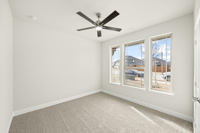 carpeted spare room featuring ceiling fan