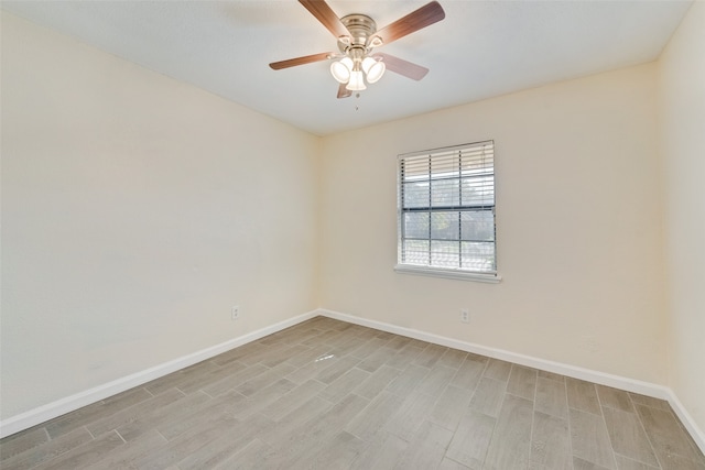 empty room with ceiling fan and light hardwood / wood-style flooring