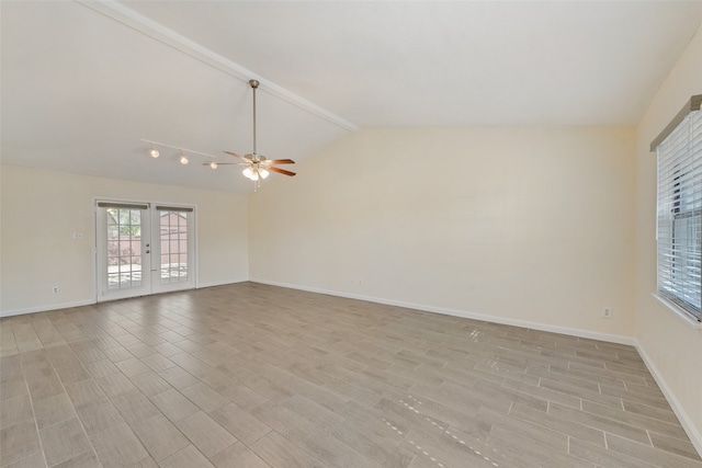 empty room featuring ceiling fan, french doors, and vaulted ceiling with beams