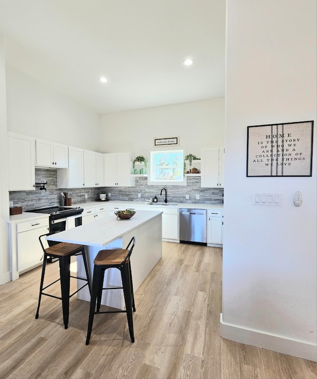 kitchen featuring light hardwood / wood-style floors, stainless steel dishwasher, white cabinets, and sink