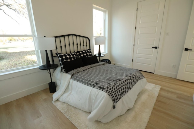 bedroom featuring light wood-type flooring and multiple windows