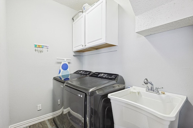 laundry area with cabinets, hardwood / wood-style floors, washer and dryer, a textured ceiling, and sink