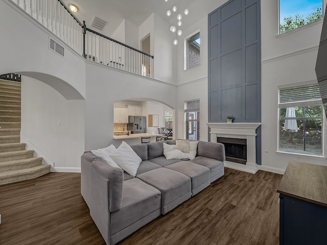 living room with a high ceiling and dark wood-type flooring