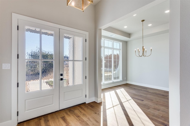 doorway to outside with light hardwood / wood-style floors, french doors, and a chandelier