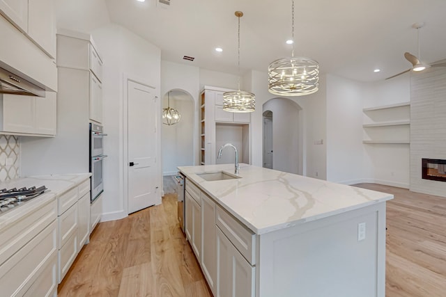 kitchen featuring sink, an island with sink, and white cabinets