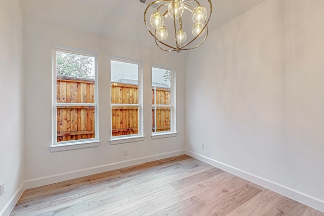 unfurnished dining area with an inviting chandelier and light hardwood / wood-style flooring