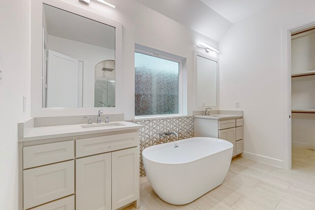 bathroom featuring vanity, lofted ceiling, and separate shower and tub