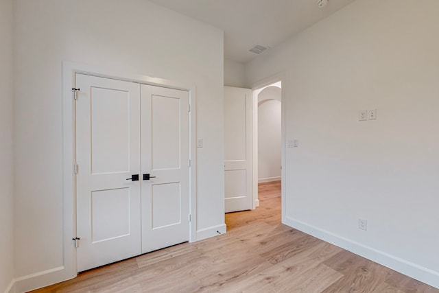 unfurnished bedroom featuring a closet and light wood-type flooring