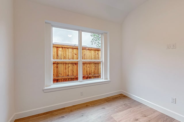 empty room with lofted ceiling and light wood-type flooring