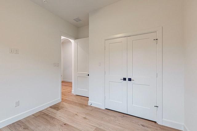 unfurnished bedroom featuring light hardwood / wood-style flooring and a closet