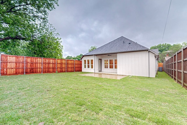 back of house with a patio area and a lawn