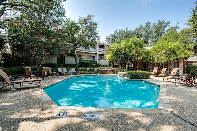 view of pool with a patio area and pool water feature