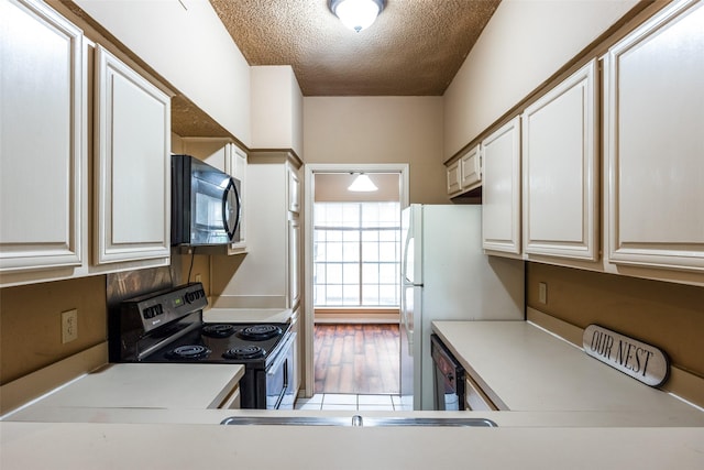 kitchen with white cabinetry, a textured ceiling, and black appliances