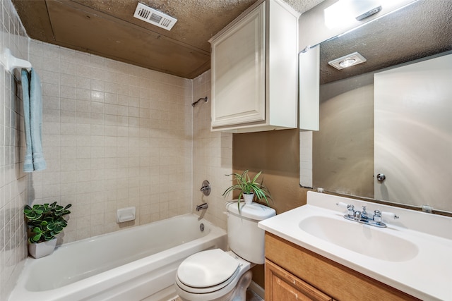 full bathroom featuring vanity, tiled shower / bath combo, a textured ceiling, and toilet