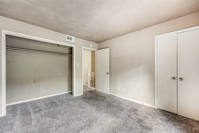 unfurnished bedroom with a textured ceiling and carpet floors