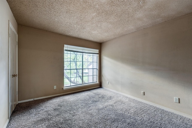 carpeted empty room featuring a textured ceiling