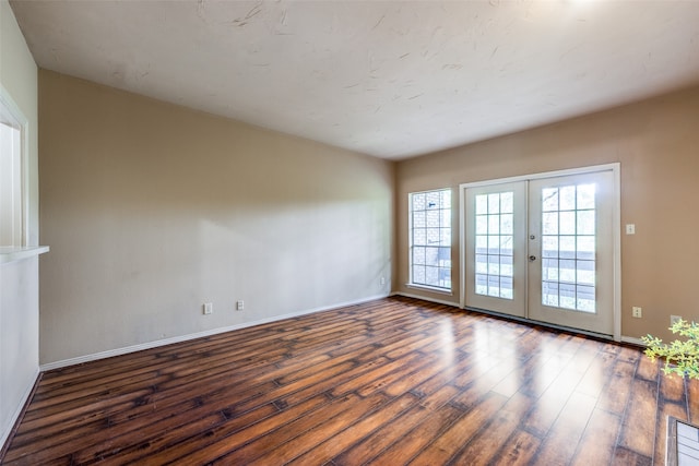 spare room with french doors and dark hardwood / wood-style floors