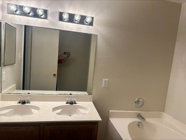 bathroom with a tub to relax in and vanity