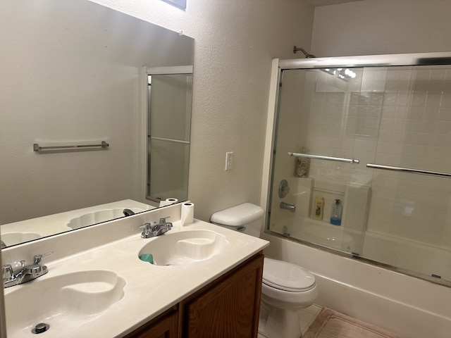 full bathroom featuring bath / shower combo with glass door, vanity, and toilet