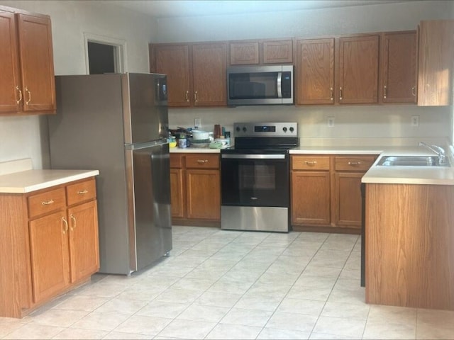 kitchen featuring light tile patterned flooring, sink, and appliances with stainless steel finishes