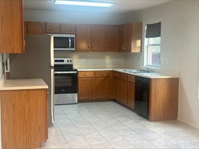 kitchen featuring stainless steel appliances, light tile patterned floors, and sink