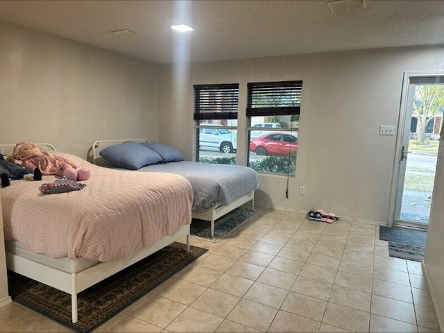 tiled bedroom featuring a textured ceiling