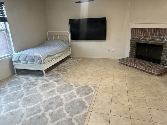 bedroom featuring a fireplace and light tile patterned floors