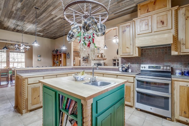 kitchen with a kitchen island with sink, sink, green cabinetry, stainless steel electric range oven, and butcher block counters