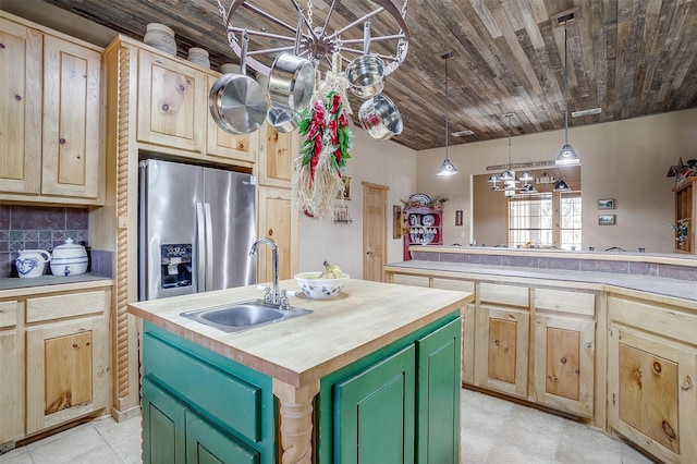 kitchen with wooden counters, green cabinets, sink, an island with sink, and stainless steel fridge with ice dispenser