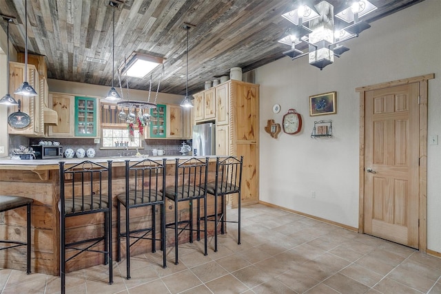 kitchen with decorative backsplash, a kitchen bar, wooden ceiling, and appliances with stainless steel finishes