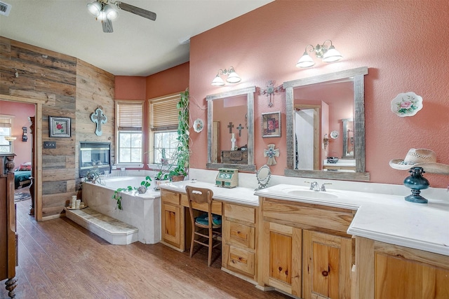 bathroom featuring a tub to relax in, ceiling fan, hardwood / wood-style floors, and vanity