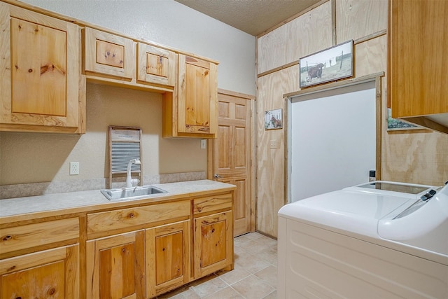 kitchen featuring washer and clothes dryer, light brown cabinets, and sink