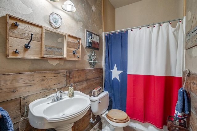 bathroom with toilet, walk in shower, and sink