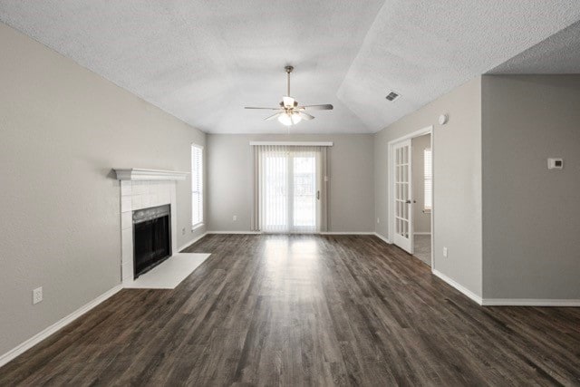 unfurnished living room with french doors, dark hardwood / wood-style floors, vaulted ceiling, a textured ceiling, and ceiling fan