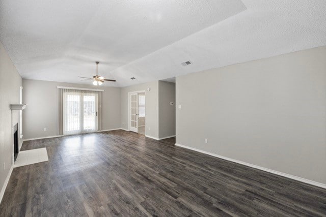 unfurnished living room with ceiling fan, a textured ceiling, and dark hardwood / wood-style flooring