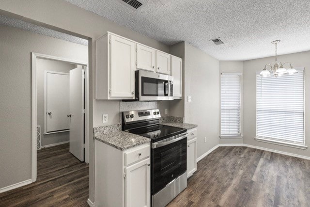 kitchen featuring hanging light fixtures, appliances with stainless steel finishes, dark hardwood / wood-style flooring, and white cabinets