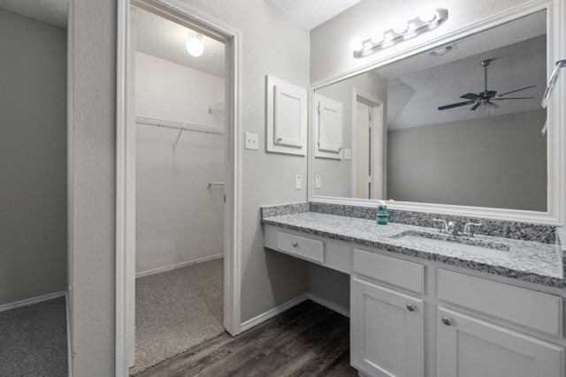 bathroom featuring vanity, a textured ceiling, hardwood / wood-style flooring, and ceiling fan