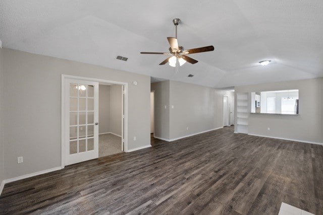 unfurnished living room featuring french doors, dark wood-type flooring, and ceiling fan