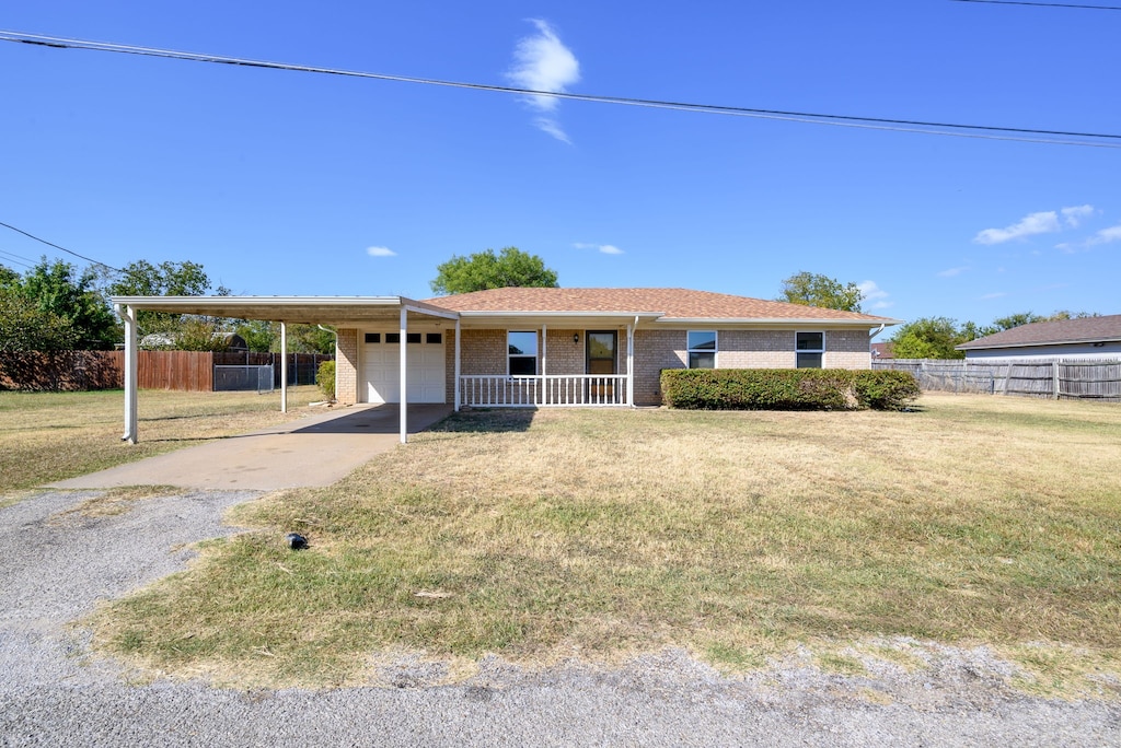 single story home with a front lawn, covered porch, and a carport