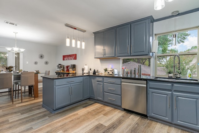 kitchen with sink, stainless steel dishwasher, kitchen peninsula, pendant lighting, and light wood-type flooring