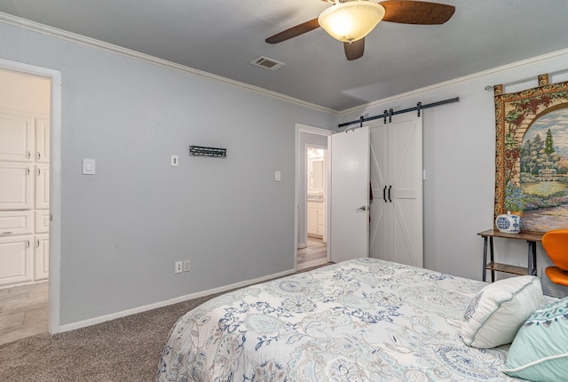 bedroom with a barn door, ceiling fan, crown molding, and carpet floors