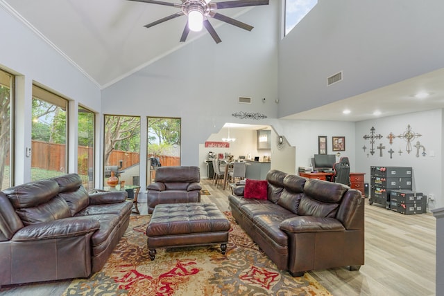 living room with high vaulted ceiling, light hardwood / wood-style flooring, ceiling fan, and ornamental molding