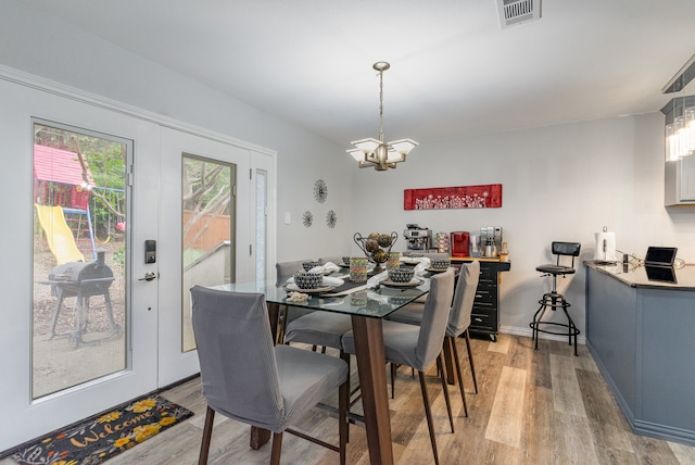 dining area featuring light hardwood / wood-style flooring and a notable chandelier