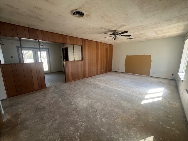 unfurnished room with wood walls and ceiling fan