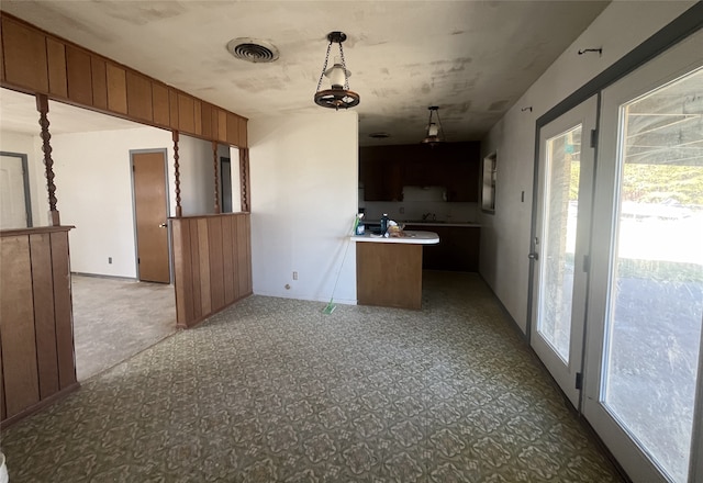 kitchen with hanging light fixtures and carpet floors