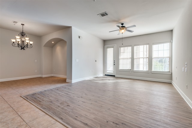 empty room featuring light hardwood / wood-style floors and ceiling fan with notable chandelier